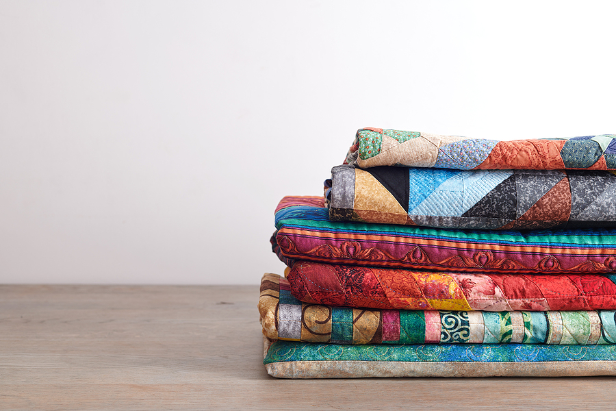 Quilts stacked on wooden table